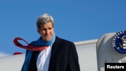 U.S. Secretary of State John Kerry reacts to the blustery weather on his arrival in Munich January 10, 2015.