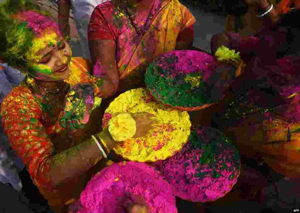 Mahasiswi India bermain-main dengan bubuk berwarna untuk merayakan Festival Holi di Kolkata.