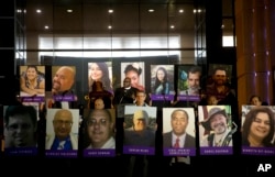 San Bernardino County employees hold up photos of the San Bernardino shooting victims during a candlelight vigil on Dec. 7, 2015, in San Bernardino, Calif.