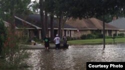 FILE - Three men prepare to kayak down their street to help out those in need, as well as find food and other supplies. (Photo courtesy of Abby TerHaar)