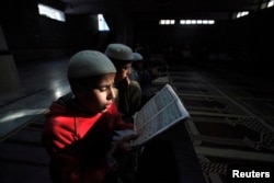 Boys recite verses from the Quran at Madrassa Arabia Taleem-ul-Quran, a religious seminary, in Lahore, Pakistan, Feb. 22, 2012.