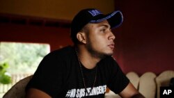 Jairo Bonilla, wearing a #WeAren'tCriminals T-shirt, gives an interview at a safe house in Nicaragua, July 28, 2018. The 20-year-old, a leader of student protests against President Daniel Ortega's government, is in hiding, trying to ignore the threats that come regularly on Facebook and in menacing text messages.