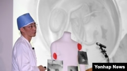 15일 수원 아주대병원에서 이국종 교수가 총상을 입은 채 귀순한 북한군 병사의 상태에 대해 브리핑하면서, 병사의 몸에서 나온 기생충 사진을 보여주고 있다.