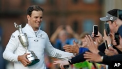 United States’ Zach Johnson celebrates with members of the public as he holds the trophy after winning a playoff after the final round at the British Open Golf Championship at the Old Course, St. Andrews, Scotland, July 20, 2015.