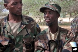 FILE - Mohamed Abdi Abdullahi, left, and Abshir Ali Mohamed, both defectors from the Somali militant group al-Shabab who became fighters with Somali government forces alongside the African Union peacekeeping force, speak to reporters at the AU base in Elasha Biyaha on the outskirts of Mogadishu, Somalia, June 7, 2012.