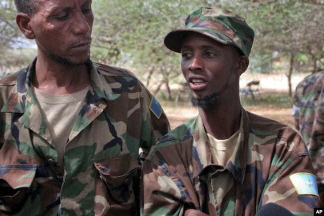 FILE - Mohamed Abdi Abdullahi, left, and Abshir Ali Mohamed, both defectors from the Somali militant group al-Shabab who became fighters with Somali government forces alongside the African Union peacekeeping force, speak to reporters at the AU base in Elasha Biyaha on the outskirts of Mogadishu, Somalia, June 7, 2012.