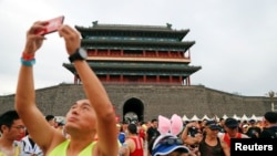 2018年9月16日在北京的广场上，人们准备参加马拉松赛。（路透社）