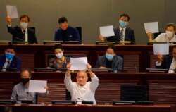 Pro-democracy lawmakers raise white papers to protest during a meeting to discuss the new national security law at the Legislative Council on July 7, 2020. AP/Vincent Yu