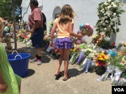 Children lay flowers outside of the Emanuel AME Church, Charleston, June 20, 2015. (Amanda Scott/VOA)