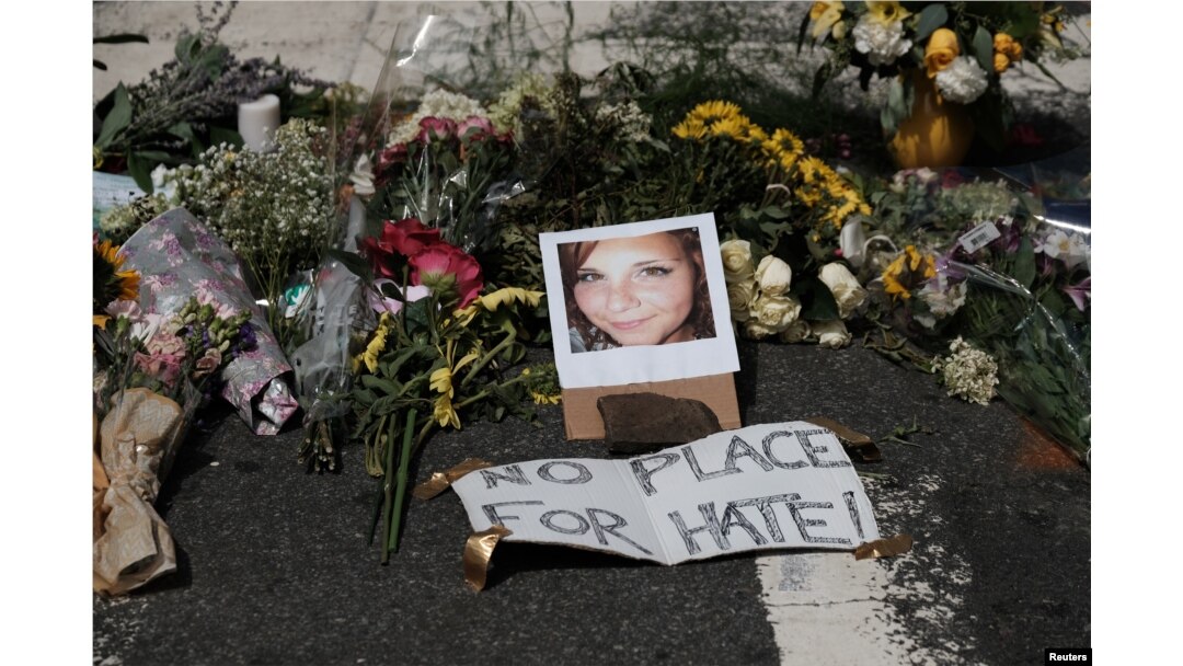 Bunga-bunga tanda belasungkawa diletakkan di sekitar foto Heather Heyer yang meninggal dalam bentrokan di Charlottesvile, Virginia.