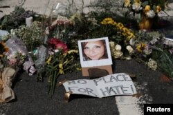 Bunga-bunga tanda belasungkawa diletakkan di sekitar foto Heather Heyer yang meninggal dalam bentrokan di Charlottesvile, Virginia.