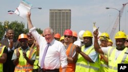 Illinois Governor Pat Quinn, surrounded by workers, holds up an approximately $1-billion capital spending plan intended to create jobs and help repair Illinois roads and bridges, during a signing ceremony in Chicago, July 22, 2014.