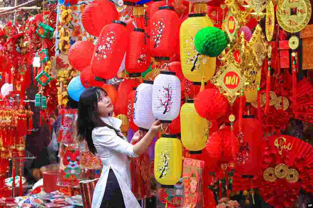 A woman looks at lanterns at the traditional Lunar New Year &quot;Tet&quot; market in the old quarter of Hanoi, Vietnam.