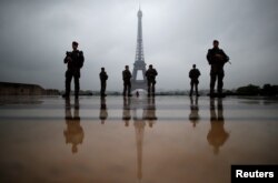 FILE - French soldiers patrol near the Eiffel Tower as part of the "Sentinelle" security plan in Paris, France, May 3, 2017.