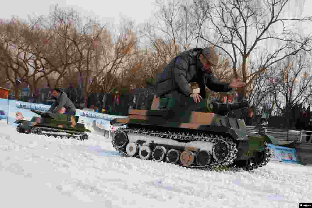 People ride in electric toy tanks in Taoranting Park on the last day of Chinese Lunar New Year holidays, in Beijing, China.