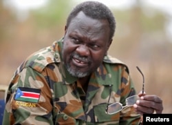 South Sudan's rebel leader Riek Machar speaks to rebel General Peter Gatdet Yaka (not seen) in a rebel controlled territory in Jonglei State, Feb. 1, 2014.