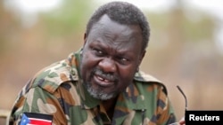 South Sudan's rebel leader Riek Machar speaks to rebel General Peter Gatdet Yaka (not seen) in a rebel controlled territory in Jonglei State, Feb. 1, 2014. 