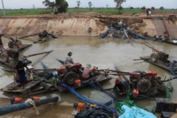 Farmers use two-wheel tractors to pump water from a twenty-kilometer irrigation system built by a Chinese company in Cambodia's western Pursat province, December 18, 2019. (Sun Narin/VOA Khmer)