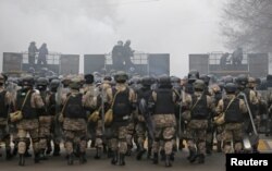 Kazakh law enforcement officers are seen on a barricade during a protest triggered by fuel price increase in Almaty, Kazakhstan, Jan. 5, 2022.