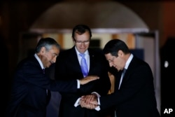 FILE - Cyprus' president Nicos Anastasiades, right, Turkish Cypriot leader Mustafa Akinci, left, and United Nations envoy Espen Barth Eide shake hands after a dinner at the Ledra Palace Hotel inside the U.N.-controlled buffer zone that divides the Cypriot capital Nicosia, May 11, 2015.