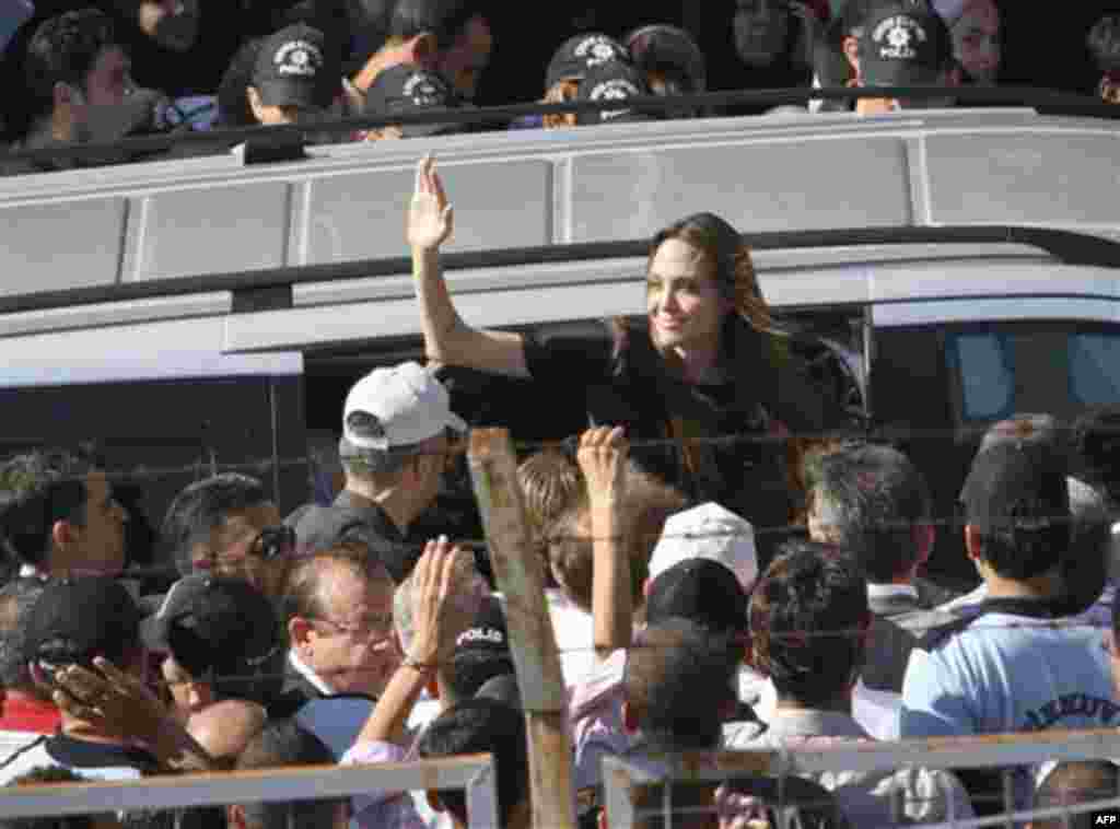 Angelina Jolie, the Hollywood celebrity and goodwill ambassador for the U.N. High Commissioner for Refugees waves as she exits a van surrounded by Syrian refugees at the Altinozu refugee camp near the Syrian border, Friday, June 17, 2011. (AP Photo/Selc