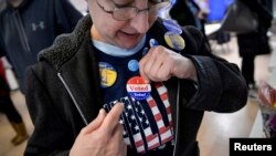 FILE - A voter puts on an "I voted" sticker during the U.S. presidential election in Philadelphia, Pennsylvania, Nov. 8, 2016. 