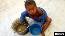 FILE - A Congolese child eats a meal at a UNHCR reception center in the Kyangwali refugee settlement camp, Uganda, March 19, 2018. 