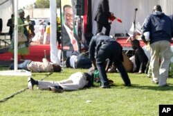 FILE - Injured people lay on the ground following an explosion at a ZANU-PF rally in Bulawayo, June, 23, 2018.