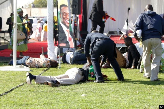 FILE - Injured people lay on the ground following an explosion at a ZANU-PF rally in Bulawayo, June, 23, 2018.