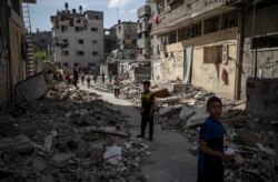 Djeca prolaze pored srušene kuće nakon izraelskih zračnih napada, grad Gaza, 17. maj 2021.