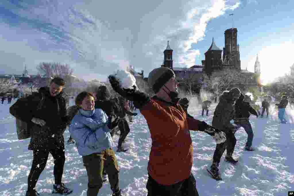 Snowballs fly during a snowball fight organized by the DC Snowball Fight Association, on the National Mall, Jan. 3, 2022, in Washington.