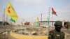 FILE - A soldier of the Kurdish Democratic Party patrols at a destroyed roundabout in the town of Snuny, close to Sinjar, northern Iraq, Jan. 29, 2015.