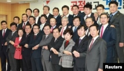 Lawmakers defecting from the ruling Saenuri Party pose for photographs during a news conference at the National Assembly in Seoul, South Korea, Dec. 27, 2016.