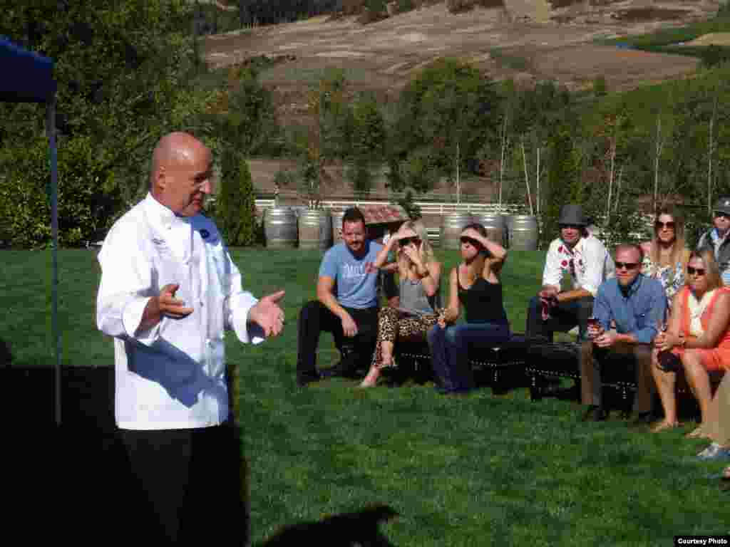 Chef Philippe Parola speaks to attendees at a Eradication by Mastication dinner at Zenith Vineyard. (Tom Banse)