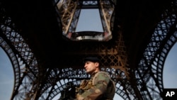 A soldier stands guard under the Eiffel Tower in Paris, France, Nov. 1, 2017 .