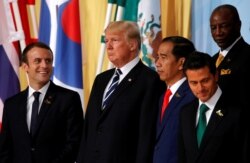 Presiden Perancis Emmanuel Macron bereaksi ketika Presiden AS Donald Trump memandang di samping Presiden Indonesia Joko Widodo dan Presiden Meksiko Enrique Pena Nieto pada KTT para pemimpin G20 di Hamburg, Jerman 7 Juli 2017. (Foto: REUTERS/Wolfgang Ratta