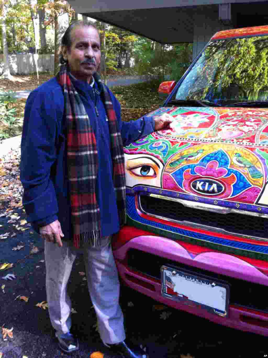 Ghulam Sarwar stands next to a Kia Sorento he painted. The Pakistan native has been in the U.S. for several months and has painted several cars in the colorful style of Pakistani trucks and buses. (VOA Photo/M. Hilburn)