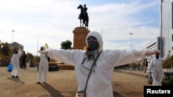 Manifestantes en trajes protectores y respetando la distancia social protestan en Santiago contra el manejo de la pandemia de coronavirus por el gobierno el 26 de abril de 2020.