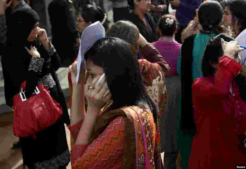 People evacuate buildings and call their relatives after a tremor of an earthquake was felt in Karachi, Pakistan, Tuesday, April 16, 2013.&nbsp;