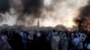 Orang-orang berkumpul di jalan saat asap mengepul di Khartoum, Sudan, di tengah laporan adanya kudeta di negara itu, 25 Oktober 2021. (Foto: RASD SUDAN NETWORK via REUTERS)