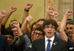 El presidente catalán Carles Puigdemont canta el himno catalán en el Parlamento luego del voto para declarar la independencia de la región. Oct. 27, 2017.