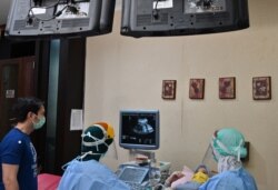 Dokter kandungan Ika Sri Purnamaningsih (tengah) menggunakan alat pelindung diri memeriksa seorang ibu hamil di RSIA Tambak, Jakarta, di tengah pandemi virus corona, 22 April 2020.