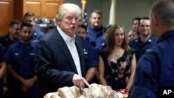 President Donald Trump prepares to hand out sandwiches to members of the U.S. Coast Guard at the Lake Worth Inlet Station, in Riviera Beach, Fla., on Thanksgiving, Nov. 23, 2017.