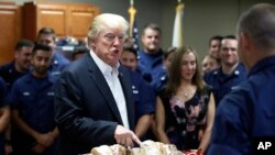 Prezidan Donald Trump ki tap prepare l pou l distribiye sandwich bay manm Gad Kòt Lèzetazini an nan Lake Worth Inlet Station, nan Riviera Beach, Eta Florid, nan okazyon Jou Aksyon de Gras la (Thanksgiving Day) jedi 23 novanm 2017 la..