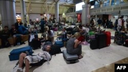 Wisatawan asing tidur di lantai saat mereka menunggu untuk berangkat dari Bandara Internasional Praya Lombok di provinsi Nusa Tenggara Barat, 6 Agustus 2018. (Foto: dok).