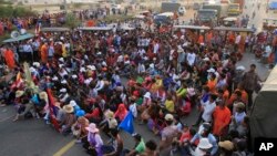 Cambodian garment workers and villagers block the main road demanding freedom for some worker activists who were arrested during Thursday's strike in Kambol village, on the outskirts of Phnom Penh, Cambodia, Thursday, Jan. 2, 2014. Troops have been used t