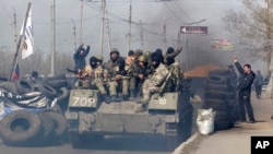 Nhóm người trên xe mặc đồ rằn ri xanh có vũ khí tự động và súng phóng lựu; ít nhất một người trong số họ có đeo dải ruy băng St. George, một biểu tượng của những người nổi dậy thân Nga ở miền Đông Ukraine. 