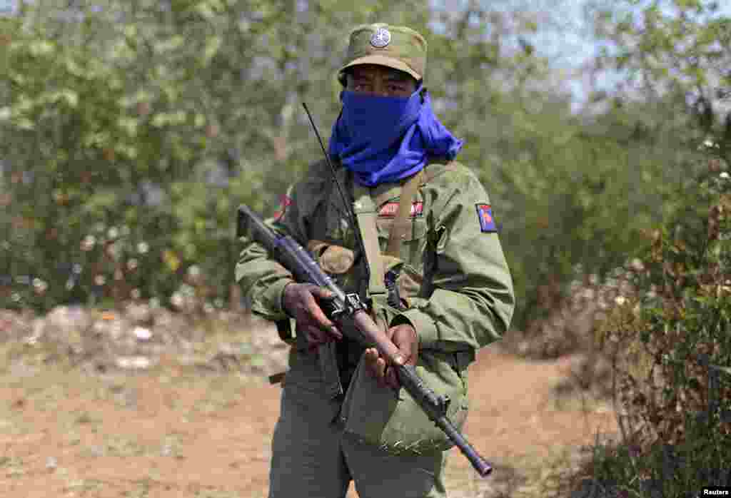 A rebel soldier of the Myanmar National Democratic Alliance Army (MNDAA) holds his rifle as he guards near a military base in Kokang region March 11, 2015. Fighting broke out last month between Myanmar's army and MNDAA, which groups remnants of the Communist Party of Burma, a powerful Chinese-backed guerrilla force that battled Myanmar's government before splintering in 1989. Picture taken March 11, 2015.