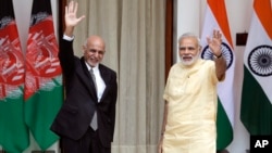 Indian Prime Minister Narendra Modi, right, and Afghan President Ashraf Ghani wave at the media before a meeting in New Delhi, India, Sept. 14, 2016. President Ghani is on a two-day visit to India.