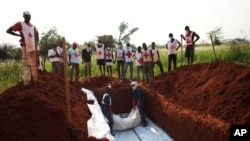 Workers from the Central African Red Cross bury 13 victims of sectarian violence in a mass grave, in Bangui, Central African Republic, Jan. 5, 2014. 